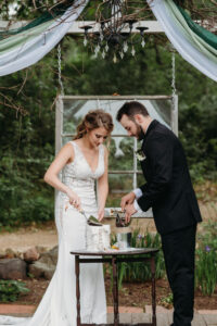 Central Wisconsin Wedding Venues bride and groom lighting unity candle during ceremony