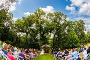 Outdoor wedding ceremony at Caribou Bay Retreat’s woodland chapel with guests seated under a canopy of trees.
