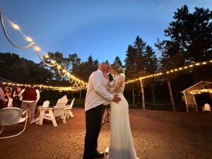 Bride and groom sharing a quiet moment under glowing string lights at Caribou Bay Retreat during their evening reception.