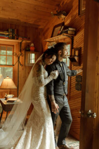 A bride rests her head on the groom’s shoulder inside a cozy wooden cabin, creating an intimate moment on their wedding day at Caribou Bay Retreat in Wisconsin.