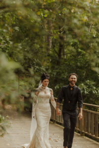 Central Wisconsin wedding venue near Appleton at Caribou Bay Retreat – couple walking hand in hand across a rustic wooden bridge