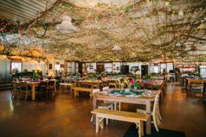 Central Wisconsin wedding venue near Wisconsin Dells at Caribou Bay Retreat – rustic reception hall decorated with grapevine ceiling and thousands of glowing twinkle lights above farmhouse tables.